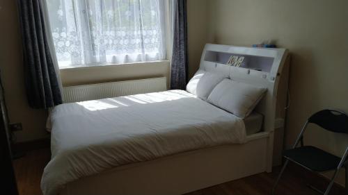 a bedroom with a white bed with a window at 119 the shaftesbury in Barking