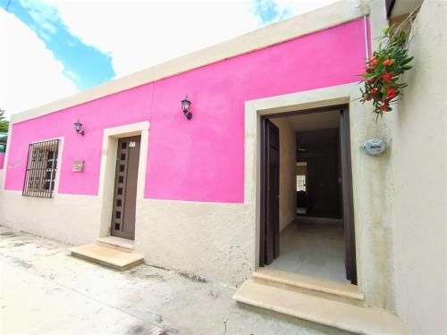 a pink building with two doors on the side at Casa Candelita in Valladolid