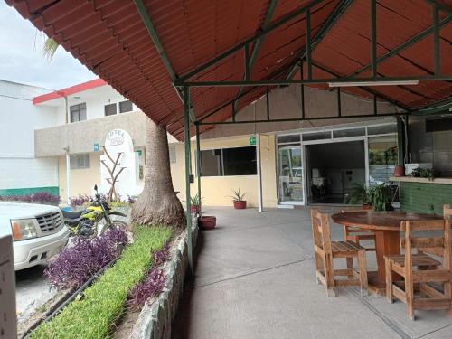 patio ze stołem i drzewem przed budynkiem w obiekcie HOTEL MARIA TERESA w mieście Rioverde