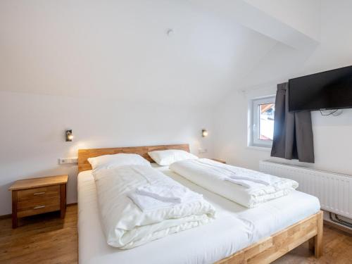 Cette chambre comprend 2 lits blancs et une télévision à écran plat. dans l'établissement Kobelhäusl bei Hause - Yannick, à Neukirchen am Großvenediger