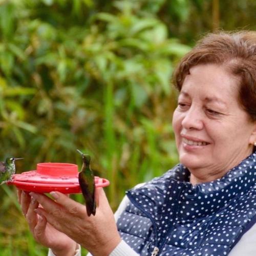 a woman holding a frisbee with two birds on it at Tambo Quinde in Tandayapa
