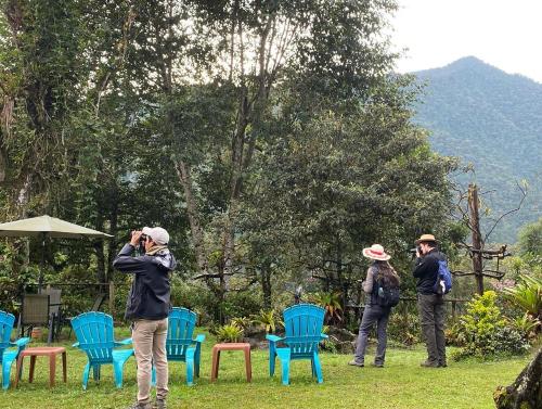 a group of people taking pictures of blue chairs at Tambo Quinde in Tandayapa