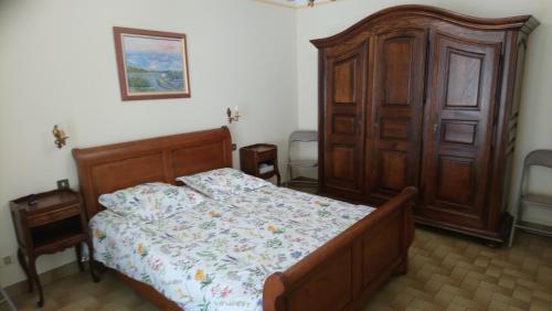 1 dormitorio con 1 cama y armario de madera en Appartement 48 m2 avec jardin au rdc dans villa à 5 min à pied des Thermes de Vernet-les-Bains, location de samedi à samedi, en Vernet-les-Bains