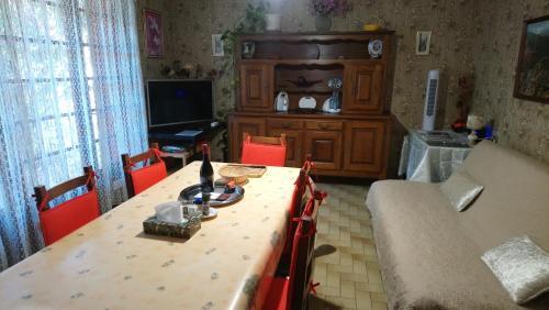 un salon avec une table avec des chaises et un canapé dans l'établissement Appartement 48 m2 avec jardin au rdc dans villa à 5 min à pied des Thermes de Vernet-les-Bains, location de samedi à samedi, à Vernet-les-Bains