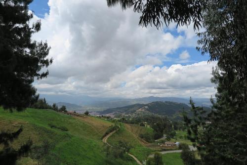a view of a green hill with mountains in the distance at Tiny Houses Premium - Casa Barcelona in Duitama