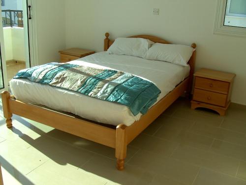 sypialnia z łóżkiem z drewnianą ramą w obiekcie Villa Margarita w mieście Protaras