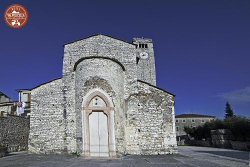an old stone church with a clock tower at Hotel Valpolicella International in San Pietro in Cariano