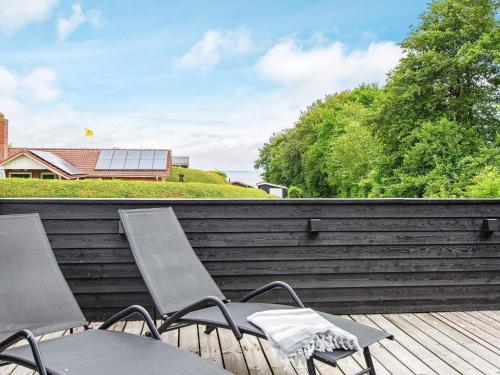 un par de sillas sentadas en una terraza de madera en 5 person holiday home in Hejls en Hejls