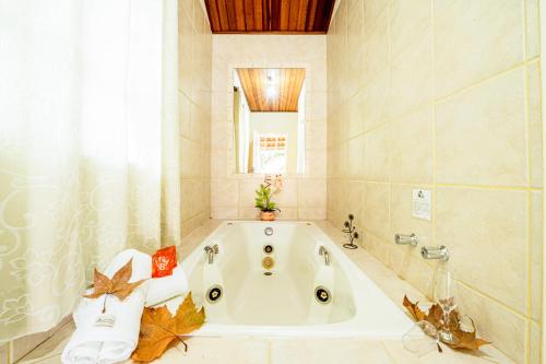 a bathroom with a bath tub with a window at Pousada Villa Da Montanha in São Bento do Sapucaí
