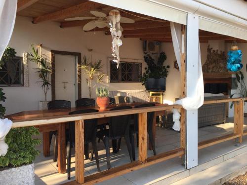 a patio with a wooden table on a deck at Ionion Seaside Home in Vartholomio