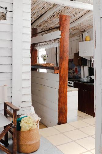 a kitchen with white walls and a wooden pole at Salty House Cabo Polonio in Cabo Polonio