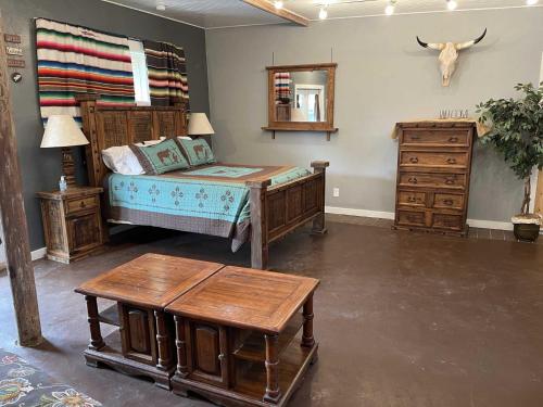 a bedroom with a bed and a table and a dresser at Trails End Retreat in Bandera