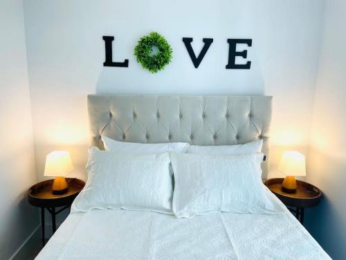 una camera con un letto bianco con due lampade sui tavoli di Lovely 2 bedroom downtown suite with free parking a Victoria