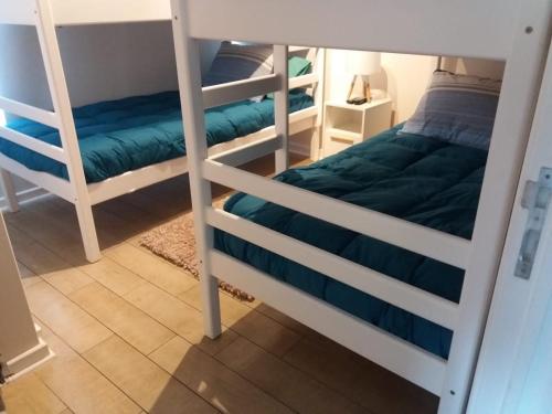 - une chambre avec 2 lits superposés et des draps bleus dans l'établissement Hermoso Departamento en Con Con Edificio Mares de Montemar, à Concón