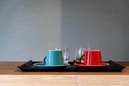 two cups and plates on a tray with glasses at Higashikawa Asahidake Onsen Hotel Bear Monte in Higashikawa