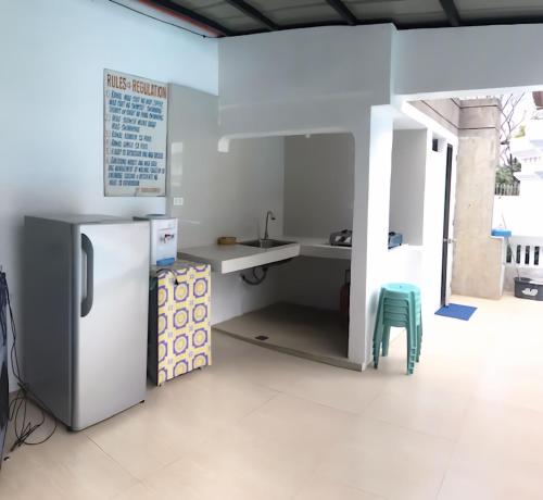 a kitchen with a refrigerator and a green stool at Deluxe Villa Leah Natural Hotspring Resort in Calamba