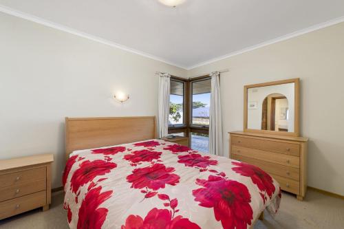 Un dormitorio con una cama roja y blanca y un espejo en SeaEsta Room for all the Family - BYO Linen, en Apollo Bay