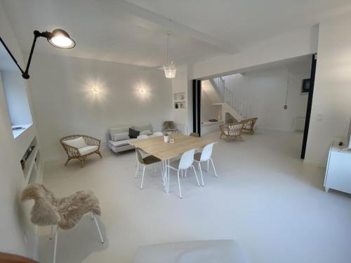 un salon avec une table et des chaises en bois dans l'établissement Gîte de Charme à Senlisse: Confort Haut de Gamme, Parc Arboré, Cheminée, Wifi Gratuit, Proche Châteaux - FR-1-527-9, à Senlisse