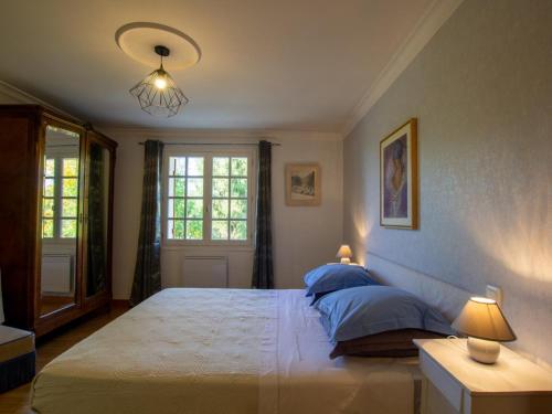 1 dormitorio con 1 cama grande con almohadas azules en Gîte Villamblard, 3 pièces, 4 personnes - FR-1-616-132, en Villamblard