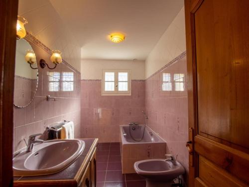 a bathroom with two sinks and a tub and a toilet at Maison de charme avec piscine privée, salle de sport proche de Bergerac et Périgueux - FR-1-616-132 in Villamblard