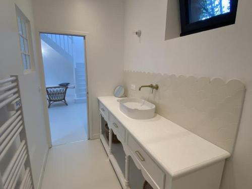 a white bathroom with a sink and a mirror at Gîte de Charme à Senlisse: Confort Haut de Gamme, Parc Arboré, Cheminée, Wifi Gratuit, Proche Châteaux - FR-1-527-9 in Senlisse