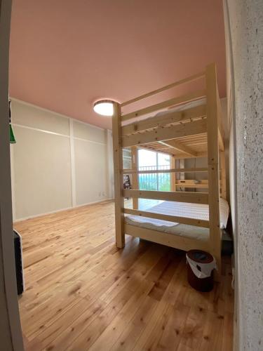 a room with two bunk beds and a wooden floor at Rokko Outdoor Station FOTON in Kobe