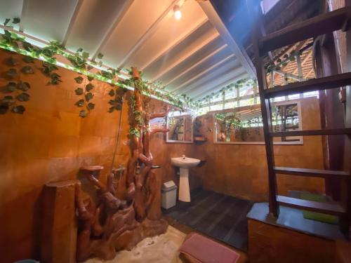 un bagno con un murale di alberi sul muro di Sejuk Cottages a Gili Air