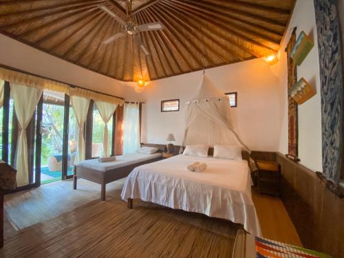 una camera con un grande letto e una grande finestra di Sejuk Cottages a Gili Air