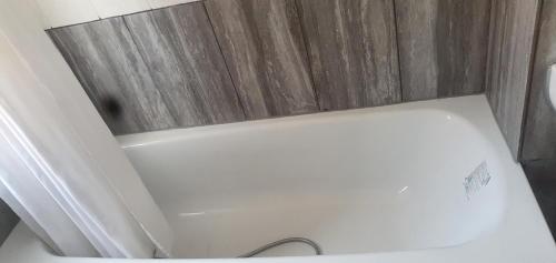a white toilet in a bathroom with wooden walls at Tower Gardens Residence in London