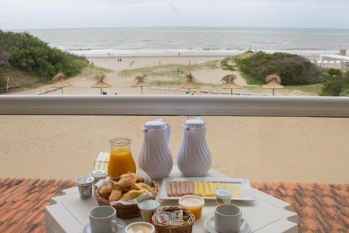 a table with breakfast food and a view of the beach at Carilo Soleil By HS in Carilo