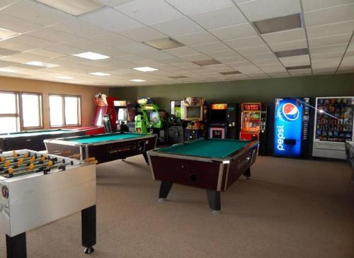 una sala de juegos con mesas de billar y máquinas recreativas en K-Suite-Mt View-Resort-Pool-Hot Tub-Near RMNP & WP, en Granby