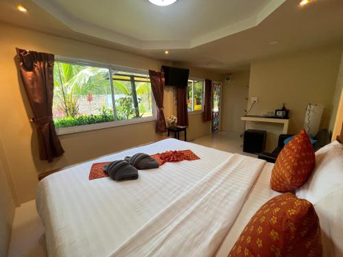 a bedroom with a large white bed with two towels on it at At Thara Aonang in Ao Nang Beach