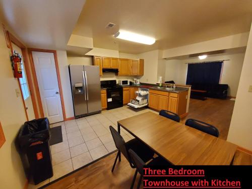 a kitchen with a wooden table and a kitchen with a refrigerator at Stay Inn and Suites in Niagara Falls