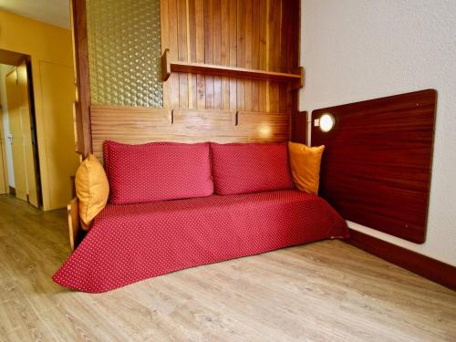 a bed with red cushions in a room at Studio Chamrousse, 1 pièce, 4 personnes - FR-1-549-90 in Chamrousse