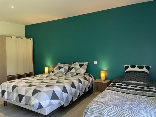 1 dormitorio con 2 camas y pared azul en Gîte Isle-et-Bardais, 3 pièces, 5 personnes - FR-1-489-389, en Isle-et-Bardais