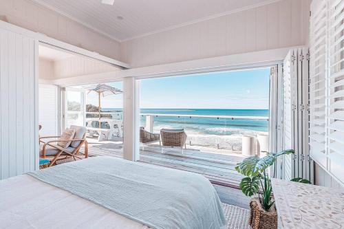 a bedroom with a bed and a view of the beach at Bay Properties Beach House Upstairs in Yamba