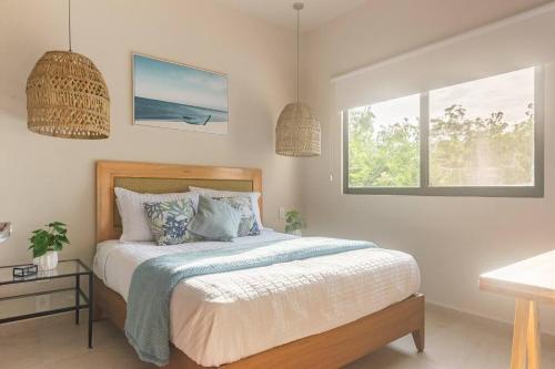 a bedroom with a bed and two windows at Aqua in Playa del Carmen
