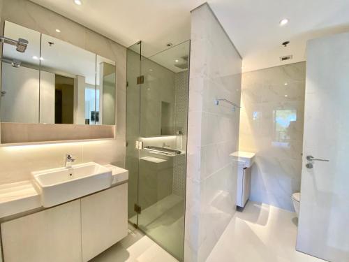 a white bathroom with a sink and a shower at Laguna cassia residences in Bang Tao Beach