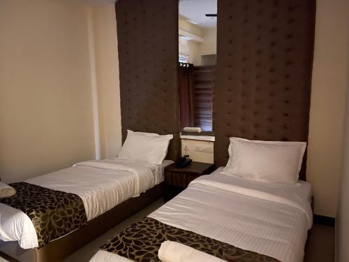 a hotel room with two beds and a window at MMD Grande A Boutique Hotel in Thanjāvūr