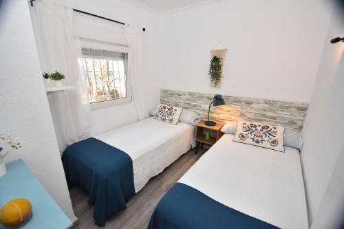 twee bedden in een kleine kamer met een raam bij Julitte 91 by homeprive in Denia