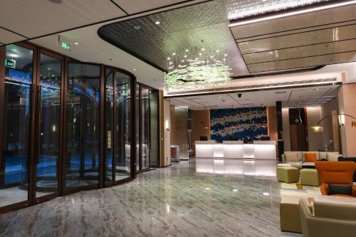 a lobby with chairs and a chandelier in a building at Holiday Inn Express Tianjin Binhai by IHG in Binhai