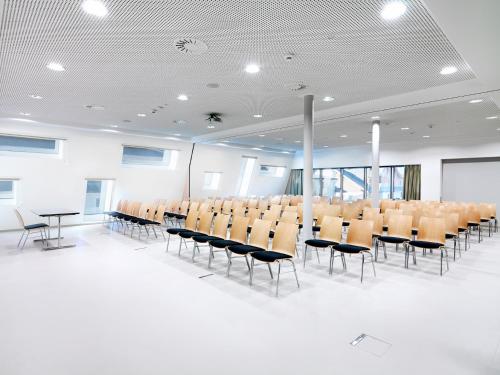 a conference room with chairs and a white floor at Alpenhotel Perner in Obertauern