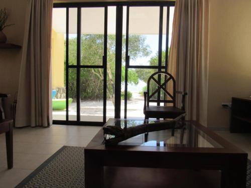 a living room with a chair and a coffee table at Two bedroom beachfront villa Celestun in Celestún