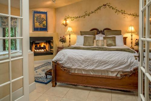 a bedroom with a large bed and a fireplace at Candlelight Inn Napa Valley in Napa