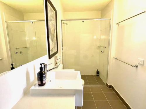 a white bathroom with a sink and a shower at THE HANGAR, alpine-getaways in Dinner Plain