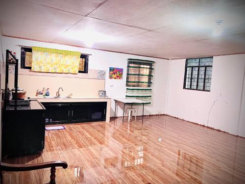an empty room with a kitchen and a wooden floor at VILLA ROUCHELE KIKAY Resthouse Vacation HOME in San Ildefonso