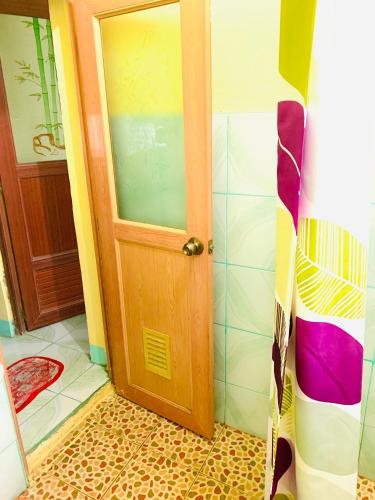 a bathroom with a wooden door in a room at VILLA ROUCHELE KIKAY Resthouse Vacation HOME in San Ildefonso