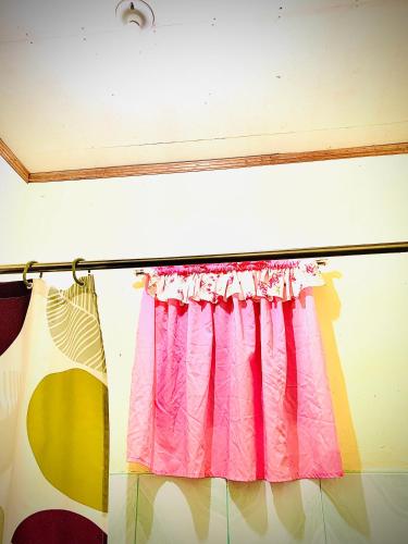 a window with a pink curtain in a room at VILLA ROUCHELE KIKAY Resthouse Vacation HOME in San Ildefonso