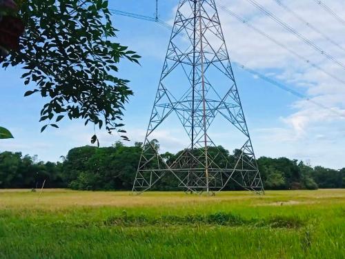 a electricity transmission tower in a field of grass at VILLA ROUCHELE KIKAY Resthouse Vacation HOME in San Ildefonso