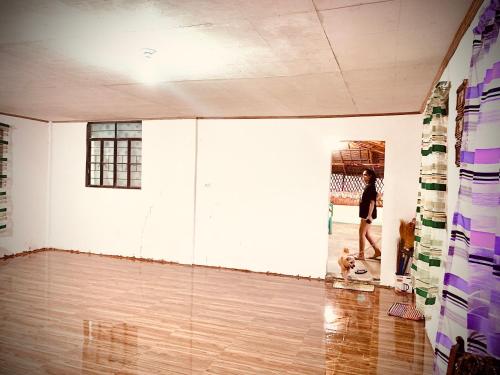 a woman standing in an empty room with a dog at VILLA ROUCHELE KIKAY Resthouse Vacation HOME in San Ildefonso